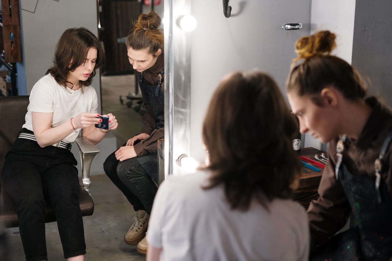 Contact Two women engaged in a hair consultation at a salon, reflecting professionalism and style.