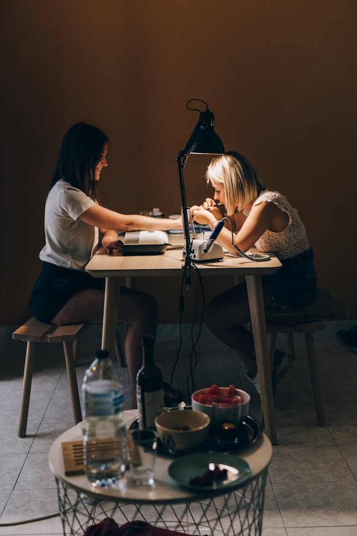 Services A nail technician providing a manicure to a client in a cozy salon setting. Focus on professionalism and care.
