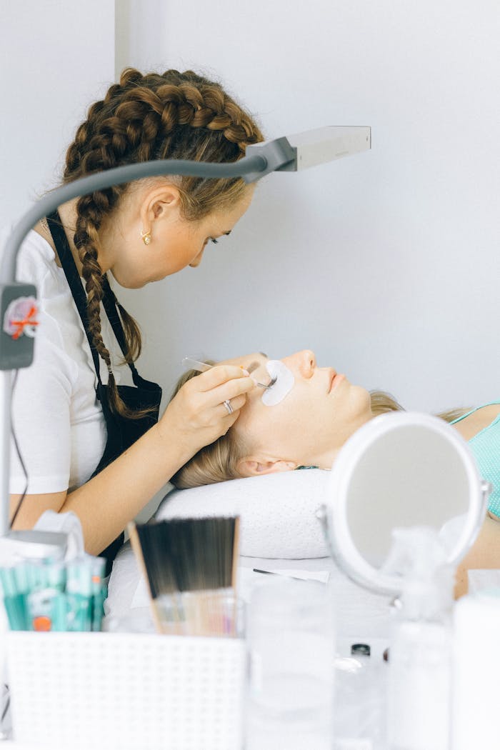 Services Beautician applying eyelash extensions in a serene salon setting, demonstrating precision and skill.