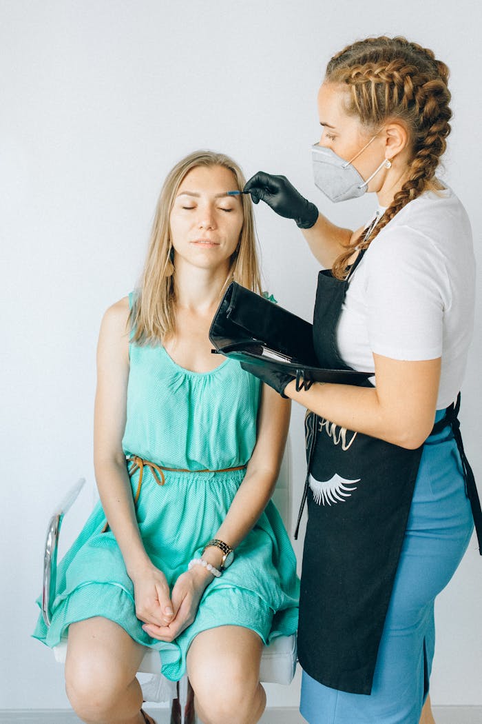 Services A beauty professional applying eyebrow treatment in a salon setting.