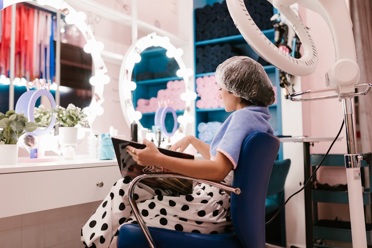 Woman enjoying a hair treatment in a well-lit beauty salon, capturing a moment of relaxation and pampering.